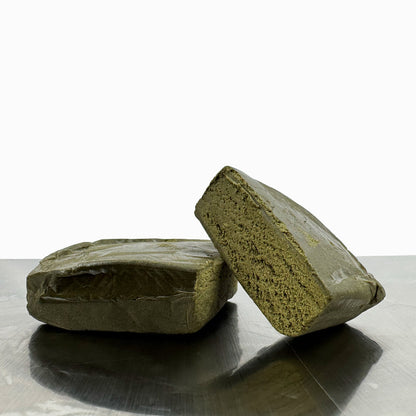 Morceau de CBD Bubble Hash coupé en deux posé sur une table