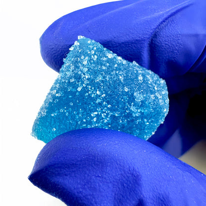 Gummies au THC bleu goûts myrtille tenu dans une main